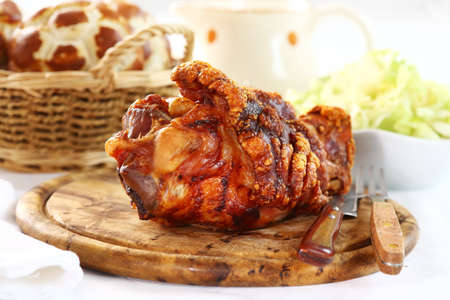 Grilled knuckle of pork with bread rolls and lettuce saladの写真素材