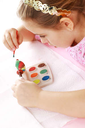 Cute little girl painting Easter eggsの写真素材