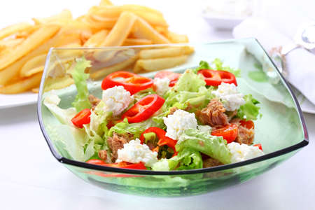Mixed vegetable salad with tuna, cottage cheese and baked potatoes in backgroundの写真素材