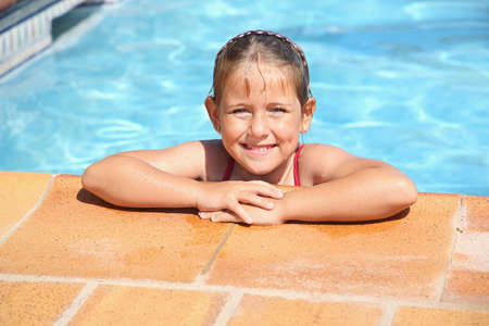 Happy girl smiling at swimming poolの写真素材