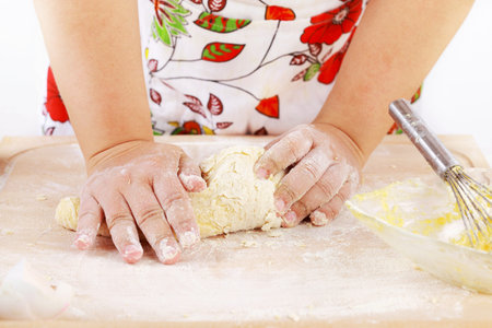 Details of woman's hands kneading dough