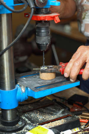 Detail of hands working on drilling machineの写真素材