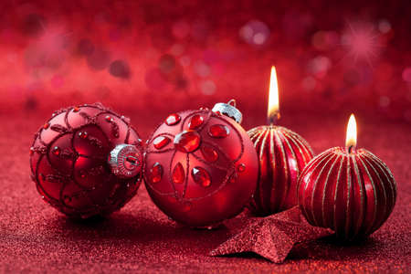 Christmas ornament with candles in red tone with glittering backgroundの写真素材