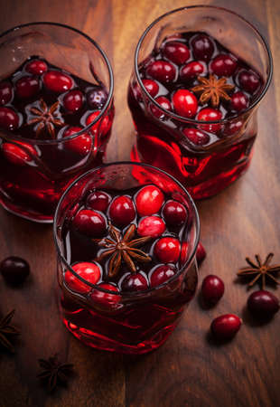 Hot drink with cranberries for Christmas on wooden tableの写真素材
