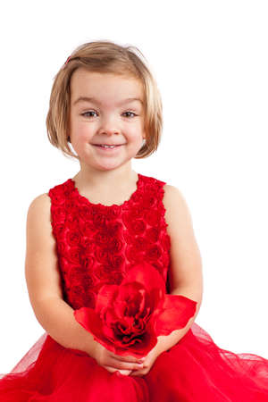 Beautiful little girl in red with red flower for her Momの写真素材