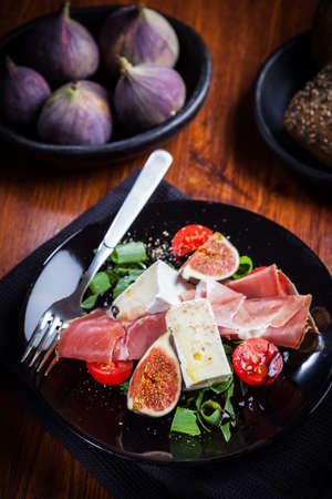 Salad with fresh figs, cheese, prosciutto and cheeseの写真素材