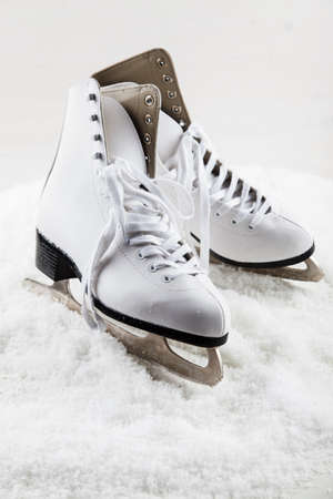 Ice skates with cap on the snowの写真素材