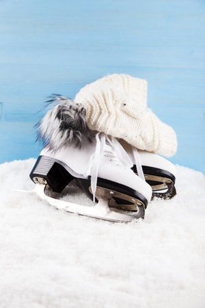 Ice skates with cap on the snowの写真素材