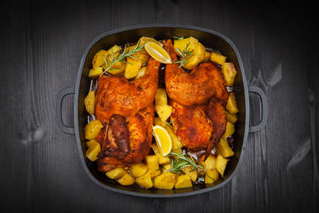 Tasty baked chicken with potatoes and herbsの写真素材