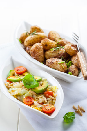 Low calorie cabbage salad with avocado and oven potatoesの写真素材