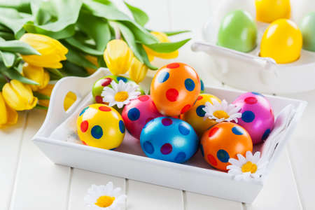 Easter eggs with spring flowers decorating tableの写真素材