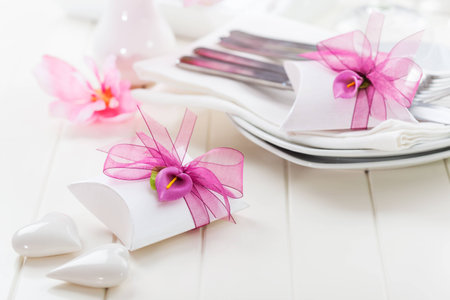 Decorated table in white with small present for the guestsの写真素材