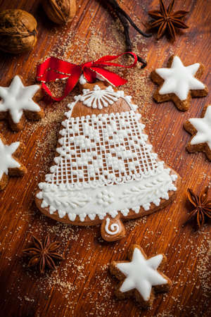 Homemade gingerbread bell for Christmas with baking ingredientsの写真素材