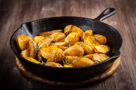 Rustic baked potatoes withherbs in a panの写真素材
