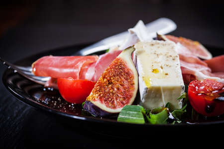Antipasti plate with fresh figs, cheese and prosciuttoの写真素材