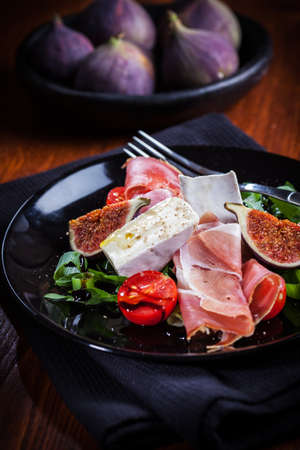 Antipasti plate with fresh figs, cheese and prosciuttoの写真素材
