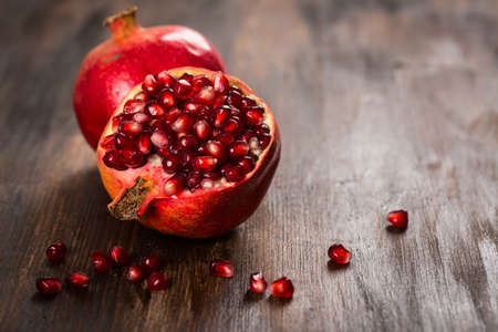 Pomegranate fruit on wooden vintage backgroundの写真素材