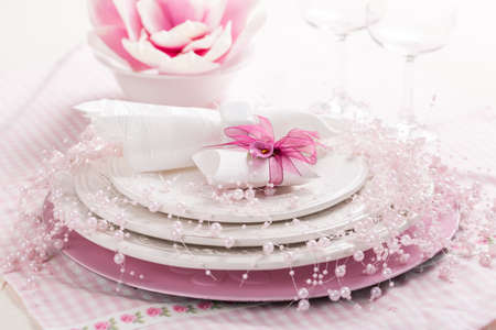 Place setting in pink tone with small present for the guestsの写真素材