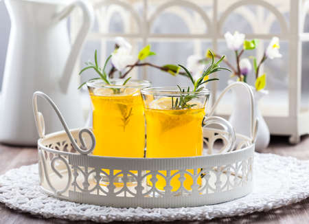 Fresh lemon drink with rosemary in glass cupの写真素材