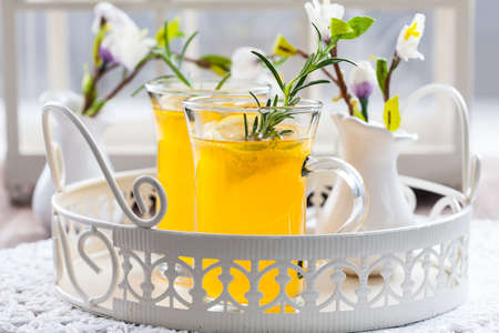 Fresh lemon drink with rosemary in glass cupの写真素材