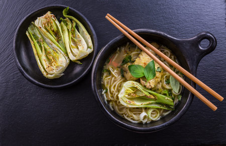 Hot Thai green curry chicken soup with pak choi and mushrooms