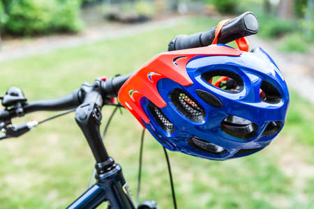 Bike helmet hangs from the handlebars of a bicycleの写真素材