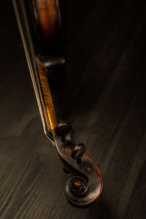Close view of old violin and strings in vintage style on wood backgroundの写真素材