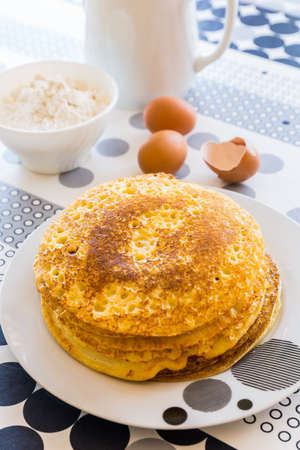 Stack of homemade pancakes with baking ingredientsの写真素材
