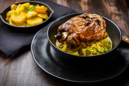 Roaster Pork Knuckle with savoy cabbage and baked potatoes - Traditional German cuisine, Eisbein, Schweinehaxeの写真素材
