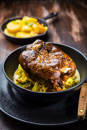 Roaster Pork Knuckle with savoy cabbage and baked potatoes - Traditional German cuisine, Eisbein, Schweinehaxeの写真素材