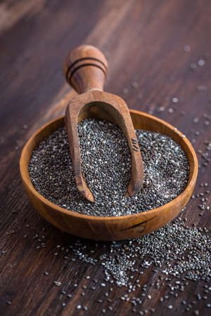 Nutritious Chia seeds with spoon in the bowl on the wooden backgroundの写真素材
