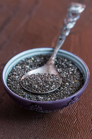 Nutritious Chia seeds with spoon in the bowl on the wooden backgroundの写真素材