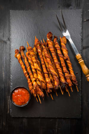 Grill skewer with hot salsa dip on black backgroundの写真素材