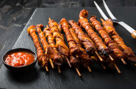 Grill skewer with hot salsa dip on black backgroundの写真素材