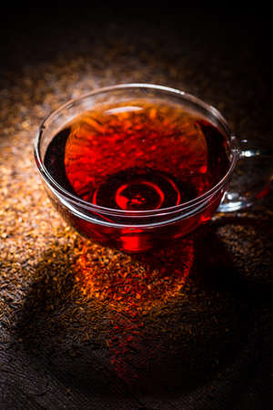 Cup of delicious rooibos tea on dark backgroundの写真素材