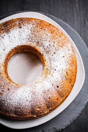 Homemade vegan banana cake baked in bundt pan decorated with powdered sugar