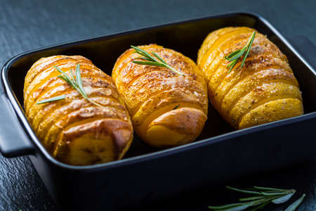 Hasselback potatoes. Backed potatoes from Sweeden with garlic and herbs grilled in the oven.の写真素材