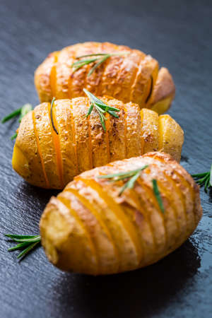 Hasselback potatoes. Backed potatoes from Sweeden with garlic and herbs grilled in the oven.の写真素材