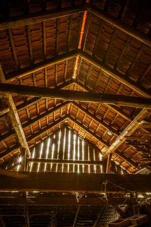 Interior of old wooden shed with scrap wood with sunrays. Old barn.の写真素材