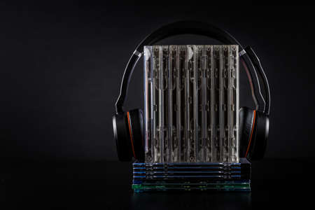 Hi-Fi headphones on stack of CDs on black background with copy space.の写真素材