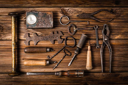 Collection of rusty tools and keys in vintage style on wooden backgroundの写真素材