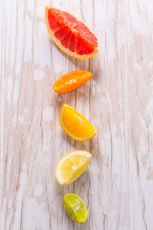 Slices of citrus fruits on wooden background. Preparing lemonade, ice tea or summer drink.の写真素材