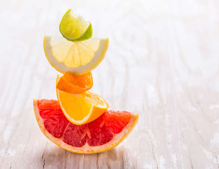 Slices of citrus fruits on wooden background. Preparing lemonade, ice tea or summer drink.の写真素材