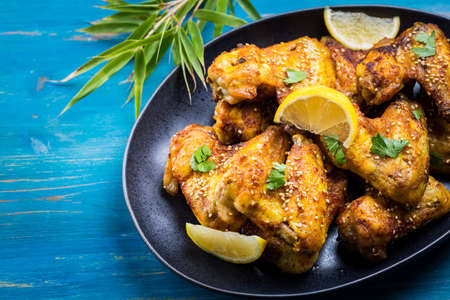 Crispy chicken wings Asia style with with sesame seeds on cyan backgroundの写真素材