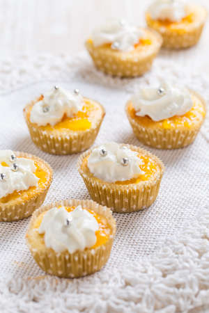 Homemade lemon curd cupcakes with whipped cream on kitchen tableの写真素材