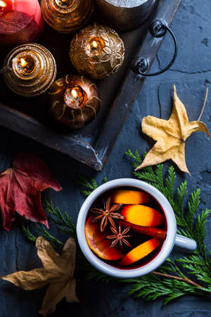 Spicy mulled wine with orange, cinnamon and anise in mugの写真素材