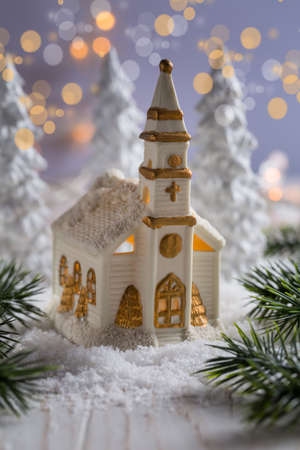 Small church with candles and white trees as snowy landscape. Christmas decoration. Symbol of Christianity.の写真素材