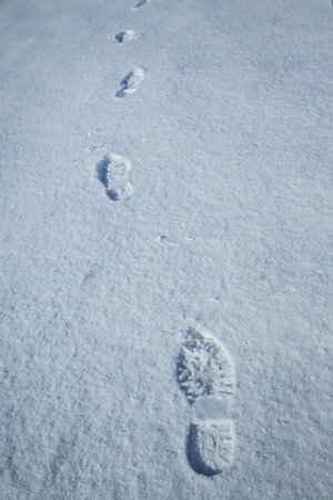 Fresh snow with morning sunlight with foot prints. Selective focus.