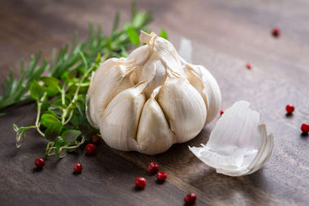 Garlic with red pepper and herbs on wooden backgroundの写真素材