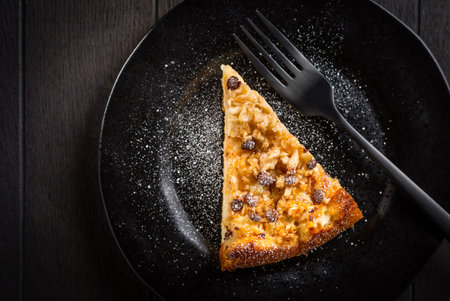 Piece of homemade apple pie with chocolate pieces for Thanksgiving on black plate
